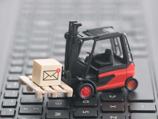Forklift with new email graphic on wooden block over laptop keyboard