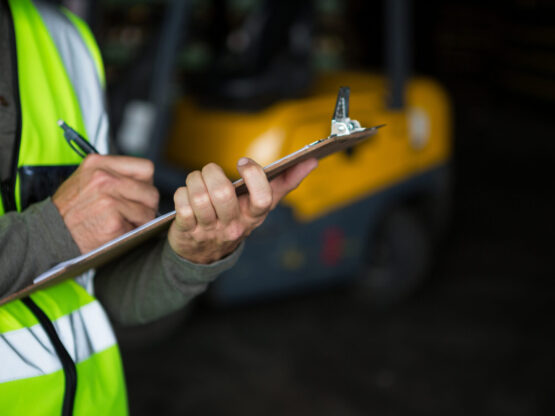 Male worker writing on clipboard in warehouse