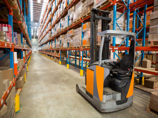 Forklift and cardboxes in shelf at warehouse